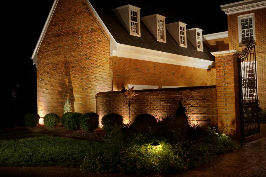 Landscape lighting behind shrubs cast a shadow on house, Springfield MO